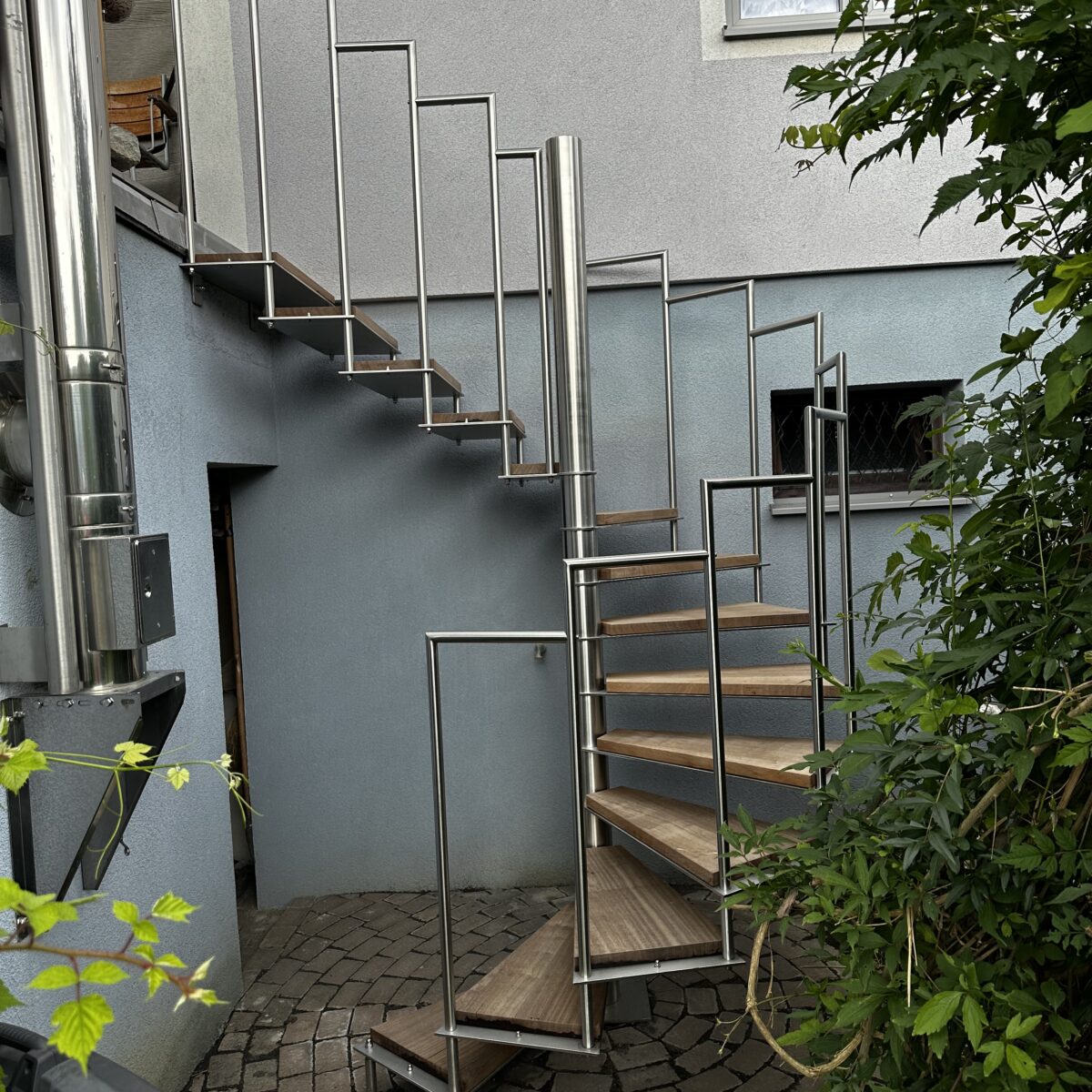 Spindeltreppe Vienna volledelstahl mit Bankirai Holztrittstufen und geradem Austritt