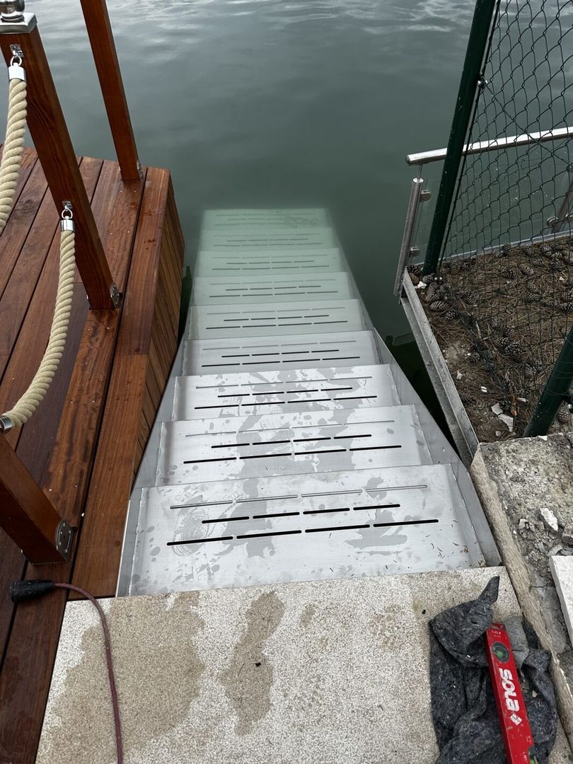 Treppe aus Edelstahl, die in einen See führt. Von oben fotografiert