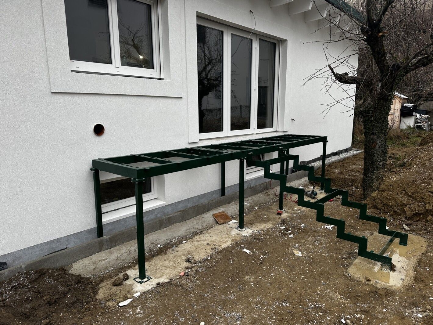 Ein unfertiges Gerüst einer Stahlwangentreppe vor einem Hauseingang