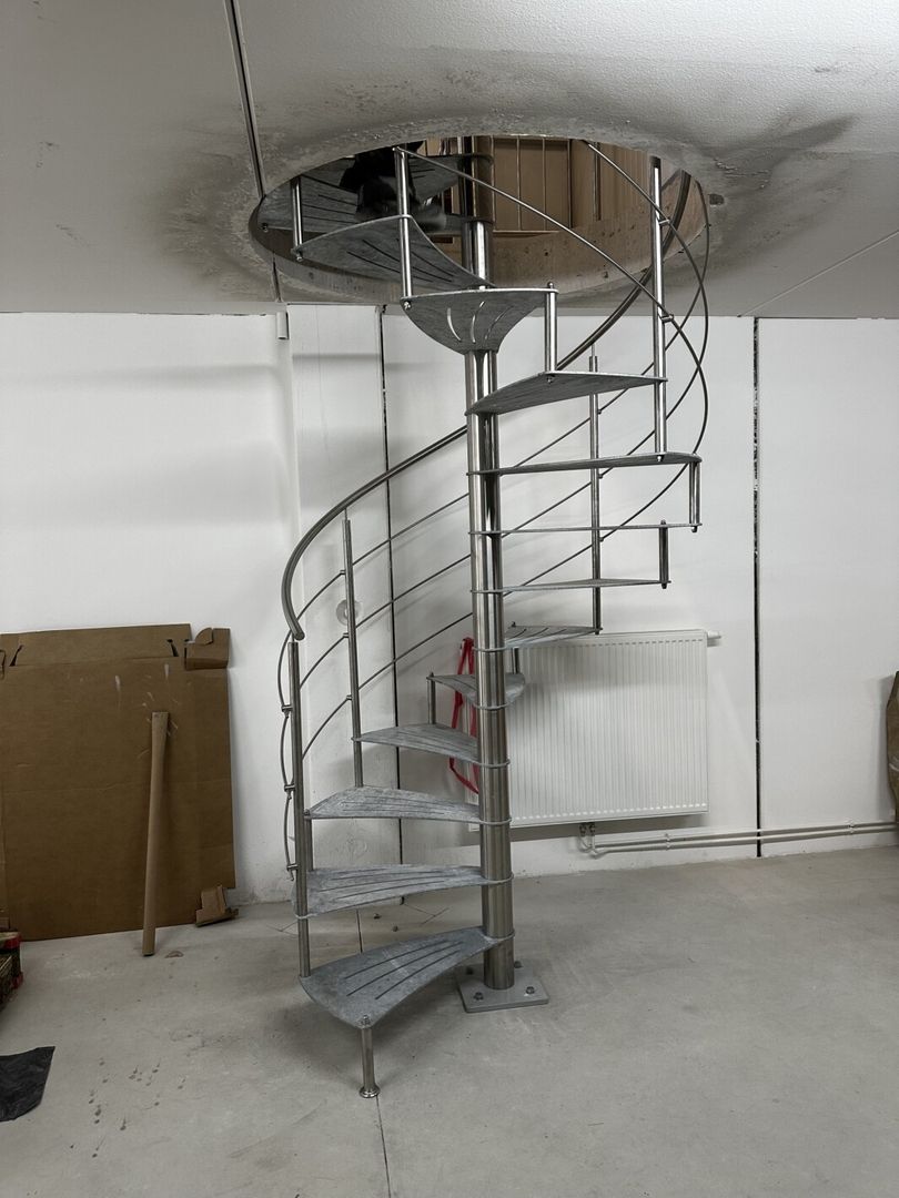 Eine Spindeltreppe aus Metall mit Metallgeländer von unten fotografiert