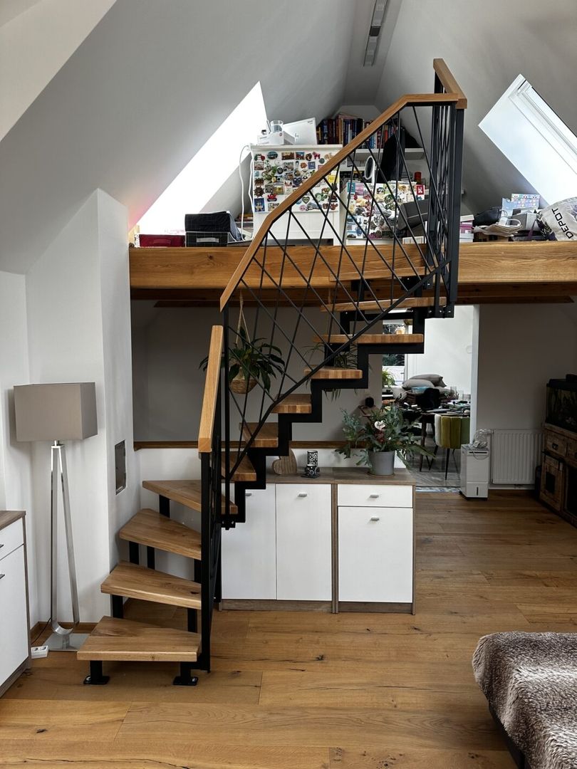 Eine Zweiholmtreppe aus Holz mit Metallgeländer in einem Wohnzimmer