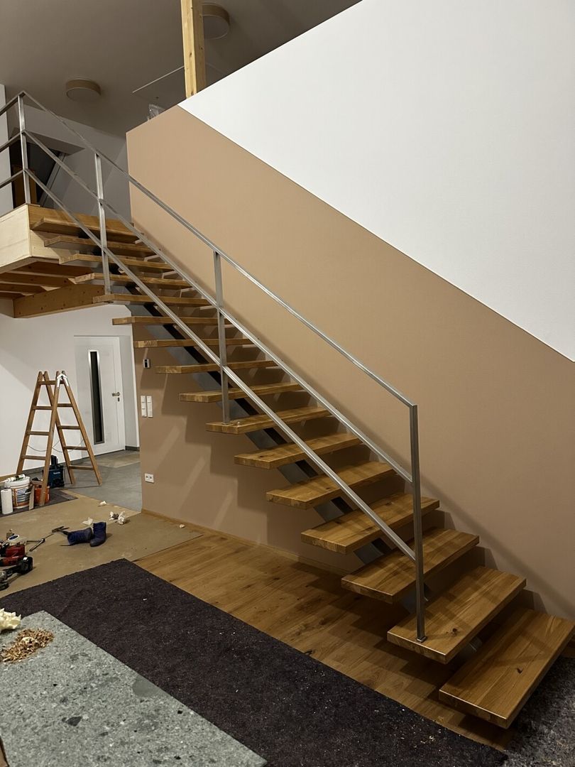 Eine Mittelholmtreppe mit Metallgeländer in einem großen Zimmer