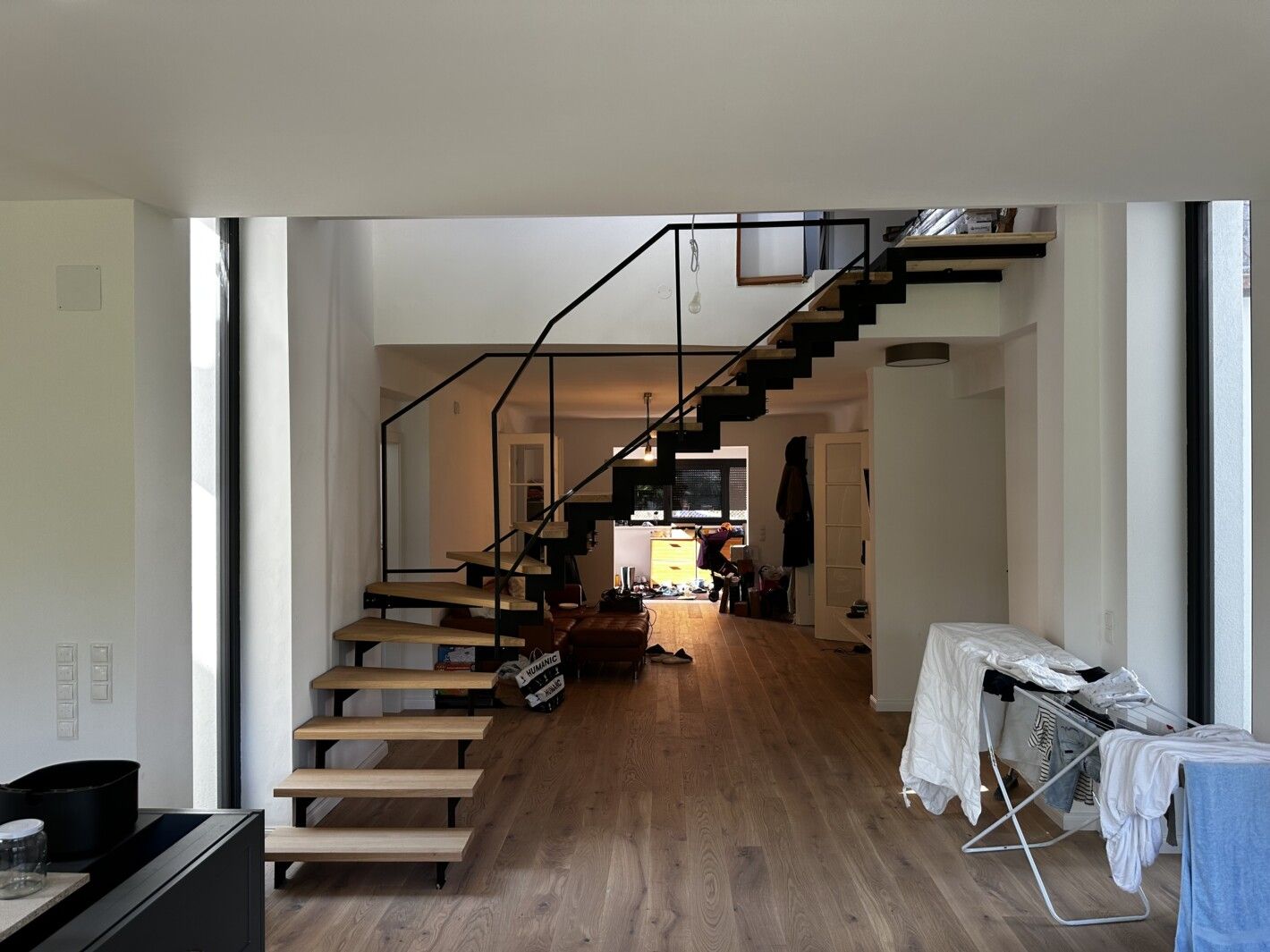 Eine Stahlwangentreppe aus Holz und Metallgeländer in einem großen Wohnzimmer