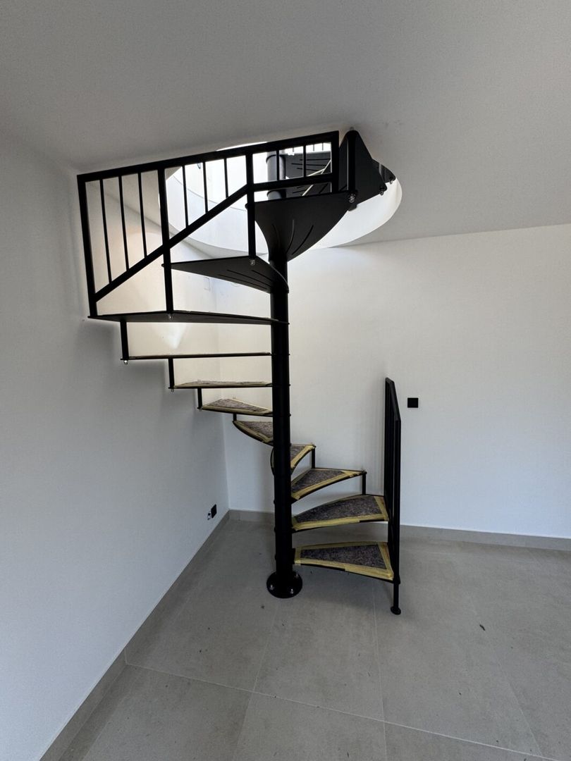 Schwarze Edelstahlspindeltreppe in einem hellen Raum