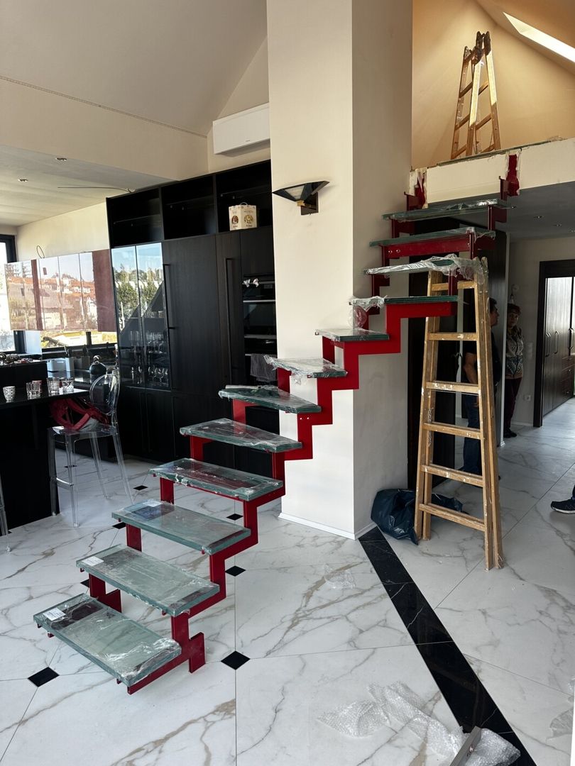 Eine rote Doppelstahlwangentreppe mit Glastreppen an einer schwarzen Küche