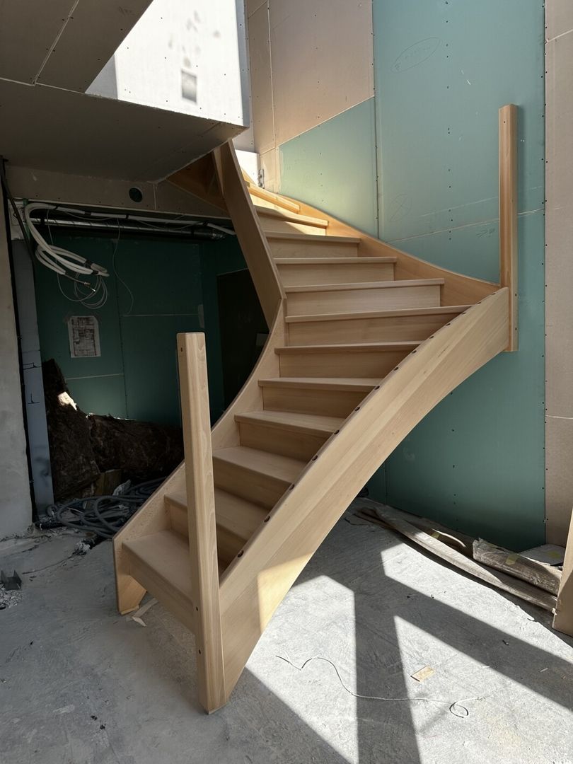 Aufbau einer Holzwangentreppe in einem unfertigen Flur von unten fotografiert