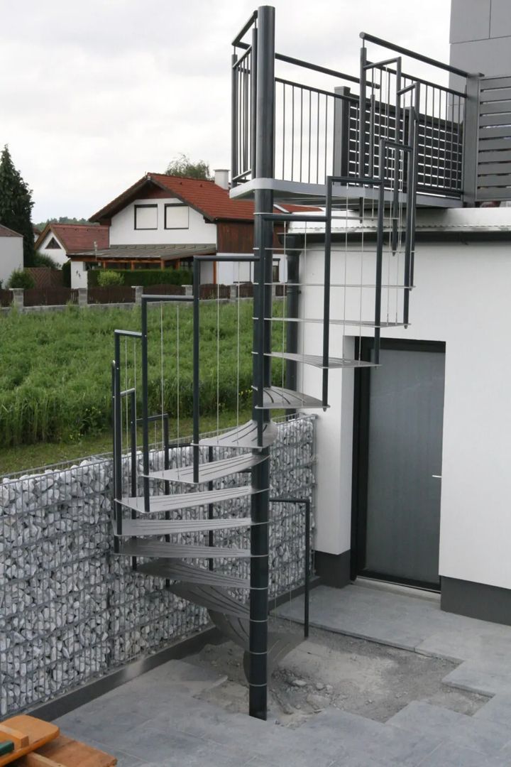 Eine schwarze Spindeltreppe an einer Außenwand