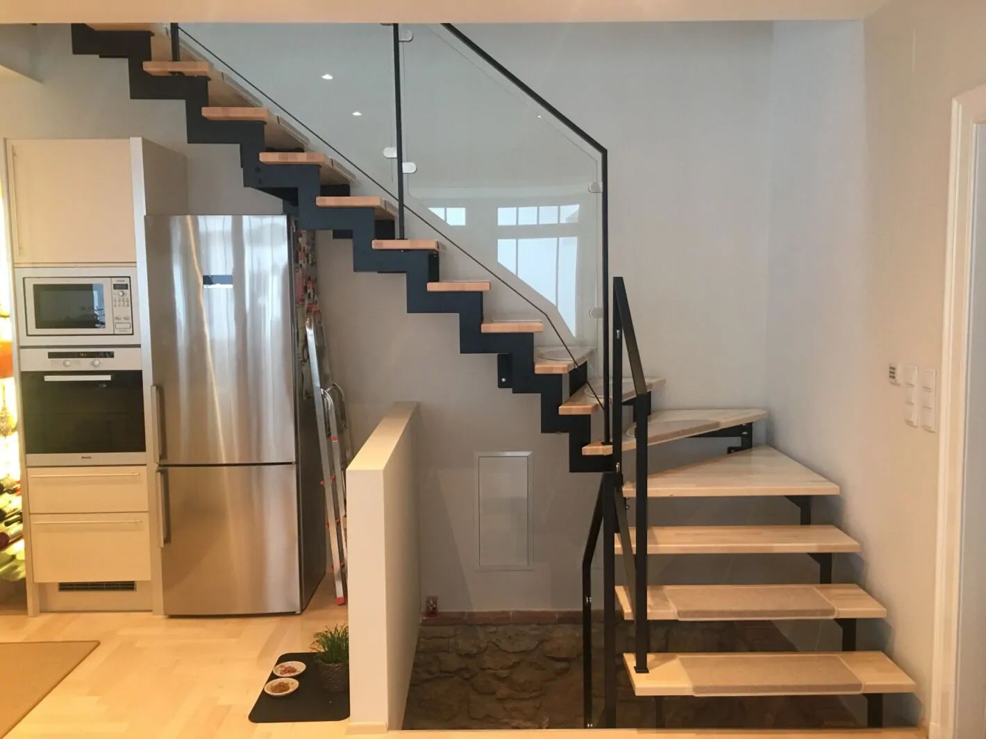 Stahlwangentreppe aus Holz und Metallgeländer mit Glas