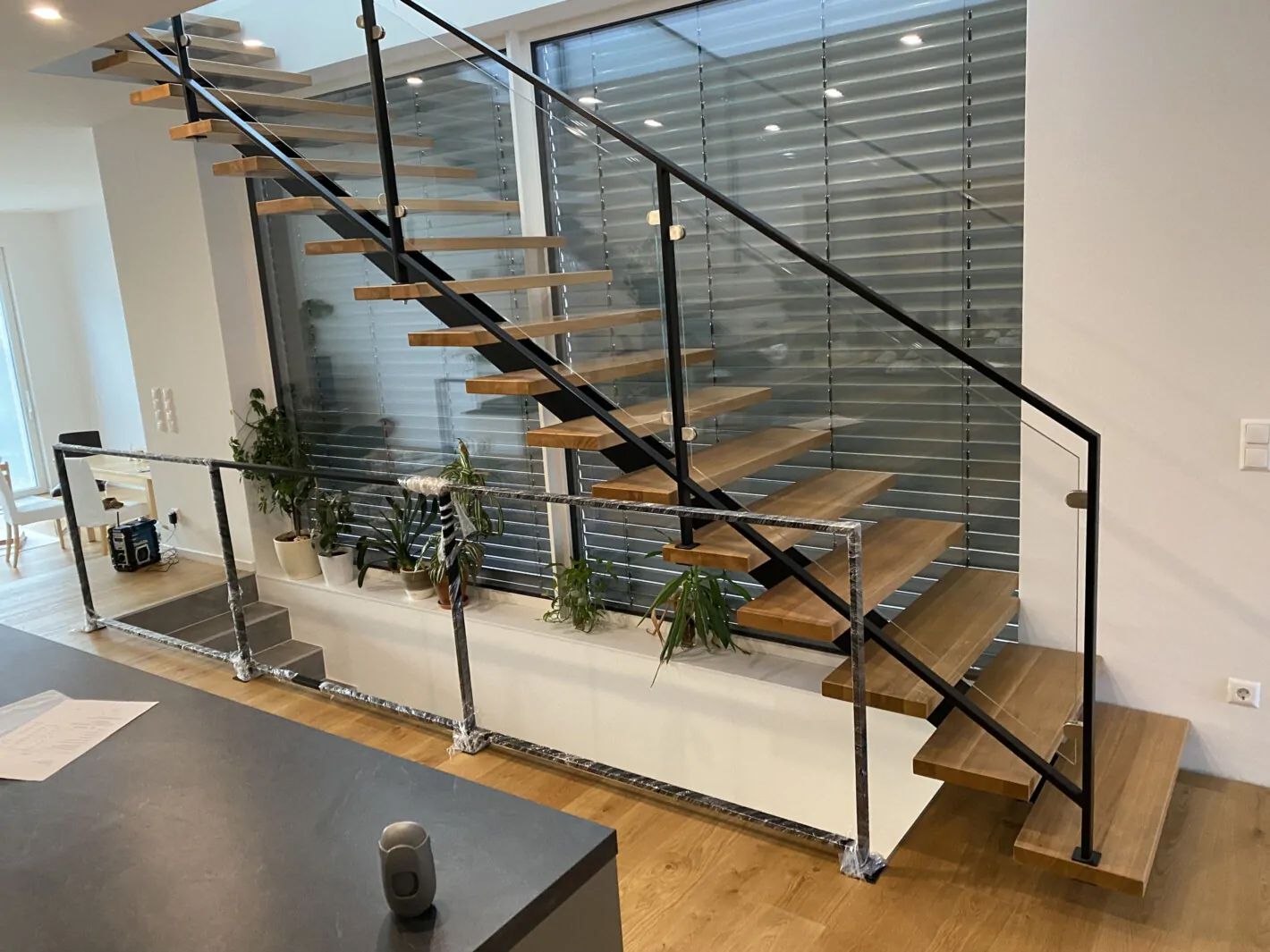 Mittelholmtreppe aus Holz mit schwarzem Geländer seitlich